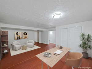 Home office featuring wood finished floors and a textured ceiling