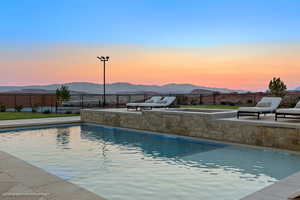 View of swimming pool with a mountain view, a fenced backyard, and a patio area