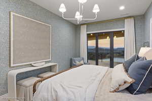Bedroom featuring wallpapered walls, access to outside, and a chandelier