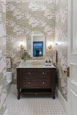 Bathroom featuring wallpapered walls and vanity