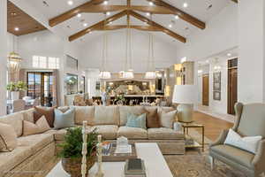 Living room with high vaulted ceiling, a chandelier, beamed ceiling, light wood-style flooring, and recessed lighting