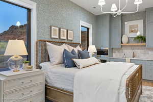 Bedroom featuring a chandelier, wood finished floors, and wallpapered walls