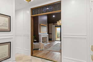 Hallway featuring a decorative wall and a chandelier