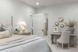 Bedroom with light carpet and an office area