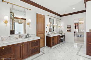 Ensuite bathroom featuring crown molding, inlaid floor details, two vanities, and recessed lighting