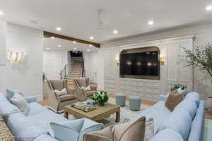Living room featuring light wood-type flooring, recessed lighting, and stairs
