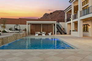 Swimming pool featuring an outdoor living space, a patio area, and stairs