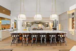 Dining room with a high ceiling, a decorative wall, and light wood finished floors