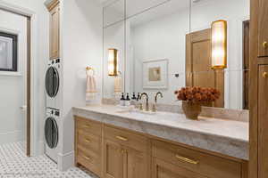 Full bathroom with stacked washing machine and dryer and vanity
