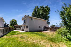 Back of property featuring a fenced backyard and a patio