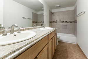 Bathroom featuring double vanity, tile patterned flooring, and shower / tub combination