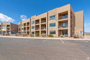 View of apartment building / complex featuring uncovered parking