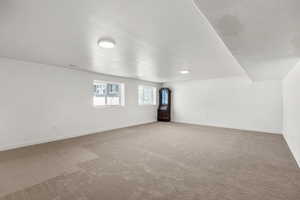 Additional living space with carpet flooring and a textured ceiling