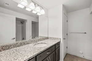 Bathroom featuring vanity, tile patterned flooring, and a shower