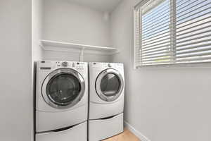 Laundry area featuring independent washer and dryer and light tile patterned flooring