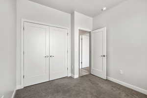 Unfurnished bedroom featuring carpet flooring and a closet
