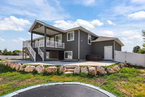 Back of house with a patio area, a gate, stairs, and stucco siding