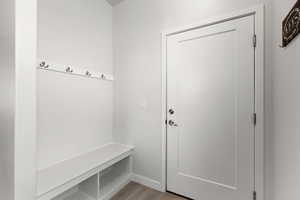 Mudroom featuring light wood finished floors and baseboards