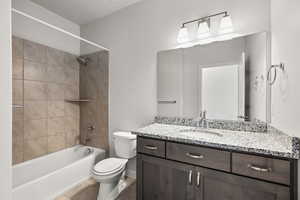 Bathroom featuring vanity, shower / bath combination, and tile patterned floors