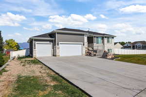 Prairie-style home with driveway, a garage, and stone siding