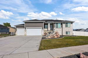 Prairie-style home featuring stone siding, concrete driveway, and a garage