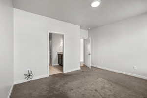 Unfurnished bedroom with carpet and connected bathroom