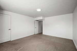 Empty room with carpet flooring and a textured ceiling