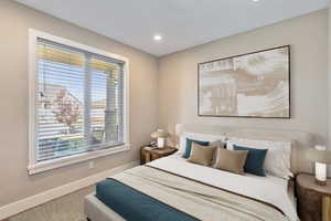 Recessed lighting illuminating the neutral-toned walls and textured carpeting