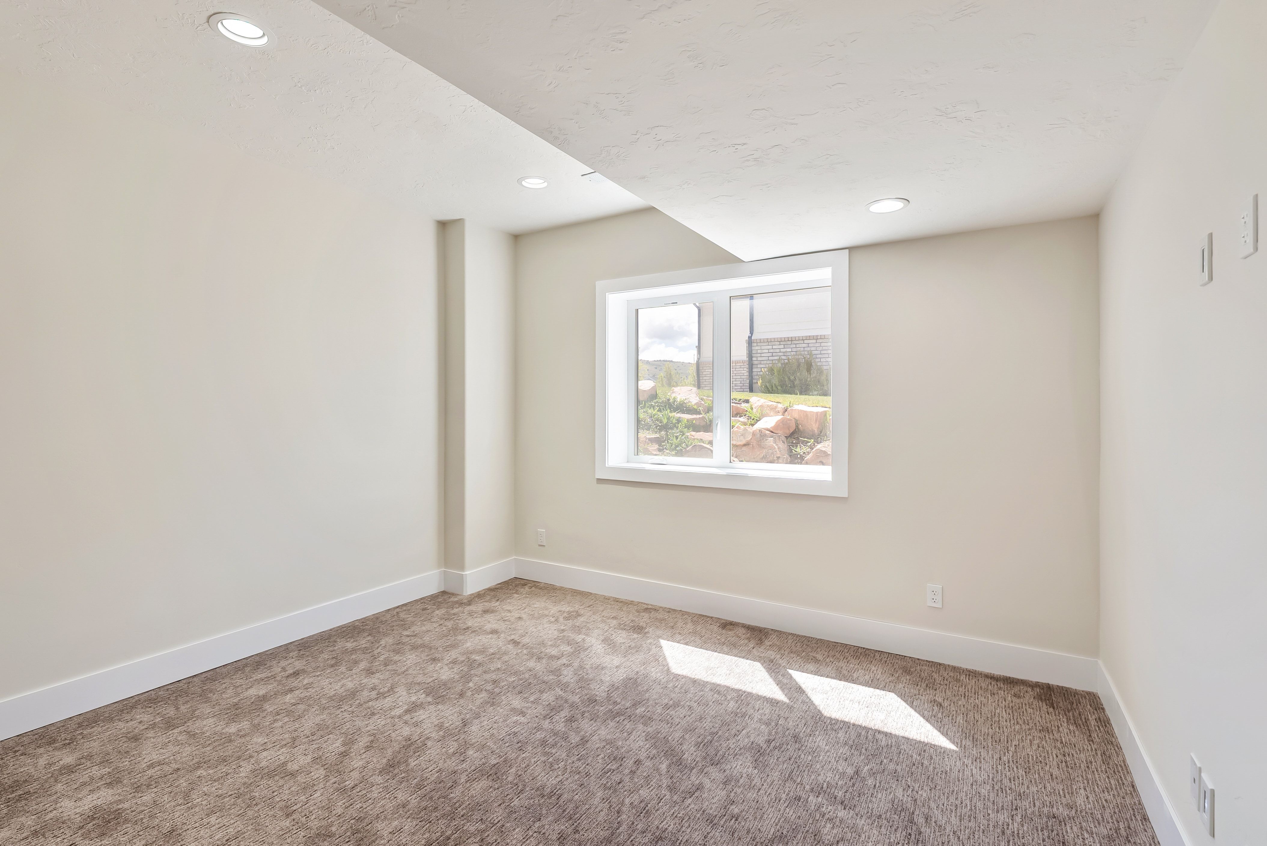 Carpeted room with recessed lighting, a white-framed window, and neutral wall paint