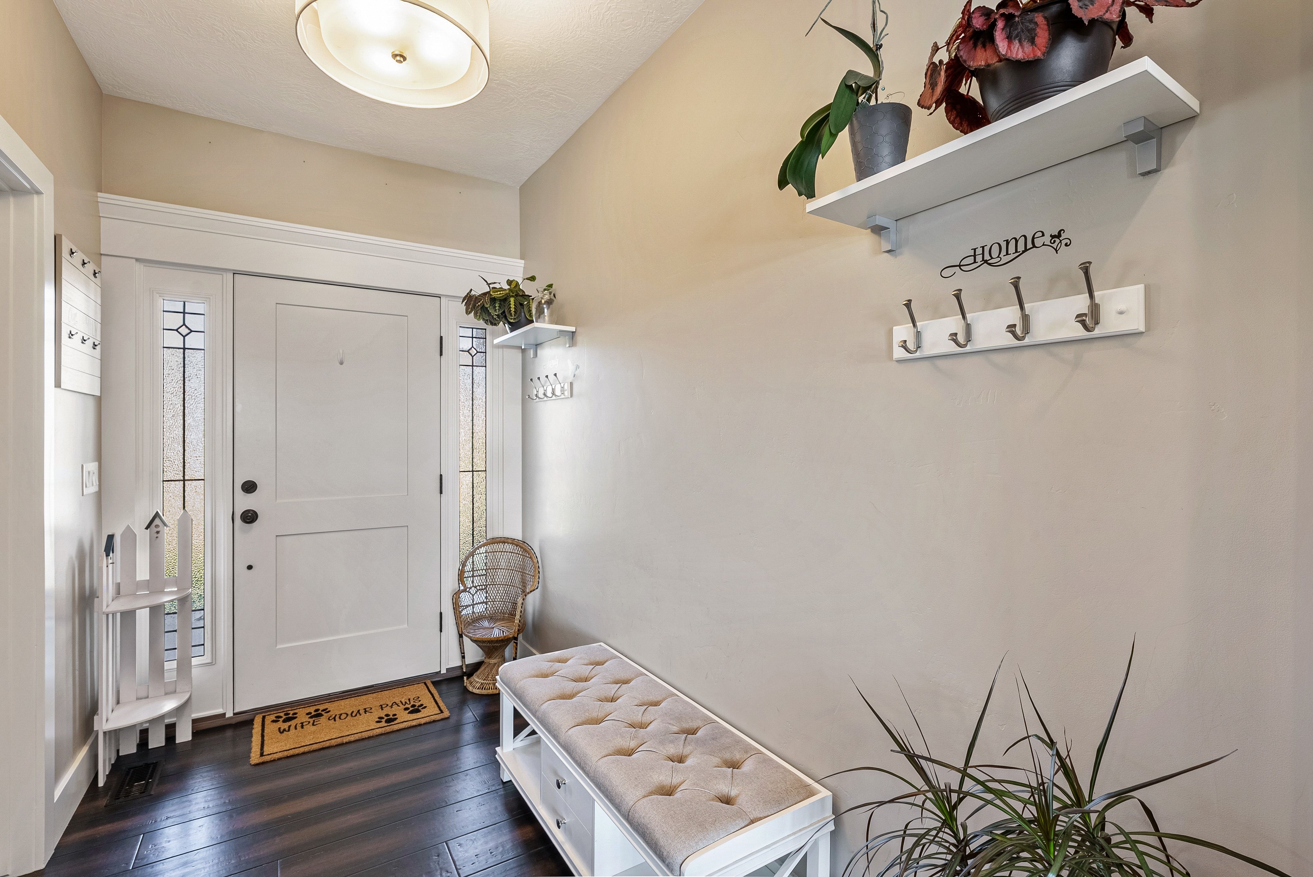 Entryway featuring a white paneled door with decorative sidelights, dark wood-finish flooring, and a flush-mount drum light fixture