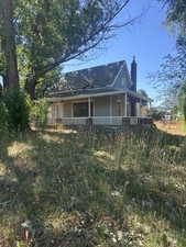 View of front of house featuring a chimney and covered porch
