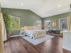 Bedroom with lofted ceiling, dark wood-type flooring, multiple windows, and recessed lighting