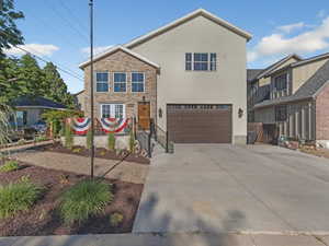 Traditional home with stucco siding, concrete driveway, and a garage