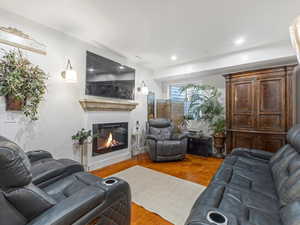 Living room featuring a glass covered fireplace and recessed lighting