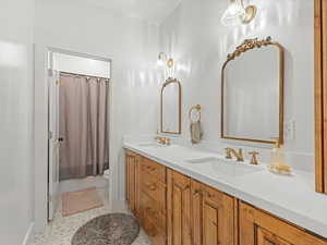 Full bathroom featuring double vanity and shower / bath combination with curtain