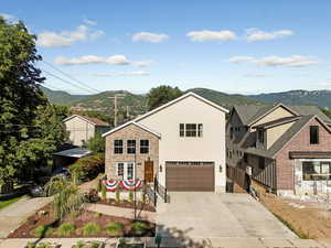 View of front of property featuring driveway, a garage, a mountain view, and stucco siding