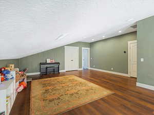 Bonus room featuring wood finished floors, recessed lighting, vaulted ceiling, and a textured ceiling