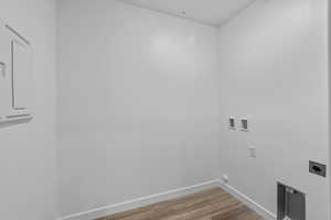 Washroom featuring hookup for an electric dryer, wood finished floors, and washer hookup
