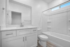 Full bathroom featuring vanity, wood finished floors, and  shower combination