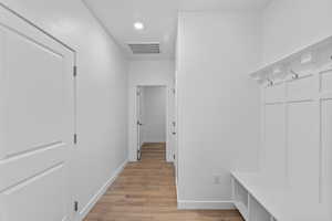 Mudroom featuring light wood finished floors and recessed lighting
