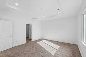 Unfurnished bedroom with a tray ceiling, carpet flooring, and recessed lighting