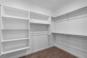 Walk in closet with dark carpet