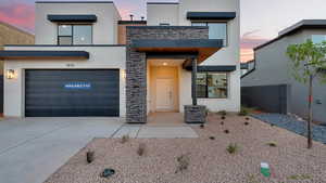 View of front of property featuring stucco siding, driveway, and stone siding