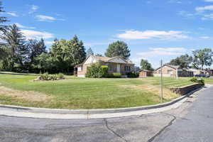 View of front facade featuring a storage shed, a front yard, and brick siding