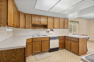 Kitchen with a peninsula, brown cabinets, and light countertops