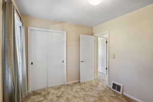 Unfurnished bedroom featuring a closet and carpet floors