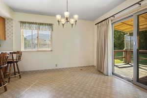 Dining space featuring healthy amount of natural light, a chandelier, and carpet floors