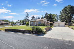 Single story home with a front yard and an outdoor structure