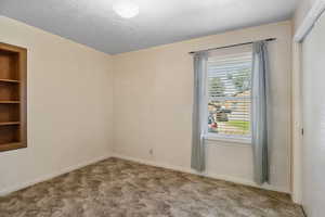 Unfurnished room with carpet floors and baseboards
