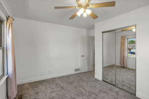 Unfurnished bedroom featuring carpet floors, a closet, and a ceiling fan